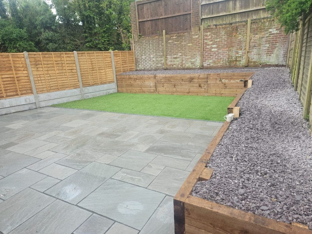 Patio and lawn separated from a gravel border by timber edging