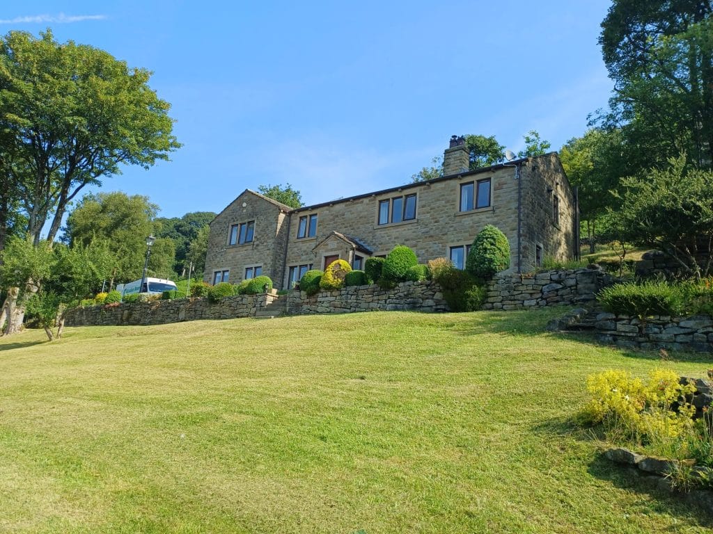 Cut lawn bordered by shrubs and residential buildings